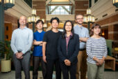 A group of researchers stands in an atrium.
