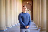 Professor Yannick Kluch standing in Memorial Stadium on the U. of I.'s Urbana-Champaign campus.