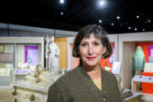 Carol Symes stands in Spurlock Museum with sculptures in the background