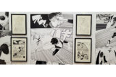 Photo of a gallery wall with black and white manga artwork -- large vinyl prints and smaller framed prints.