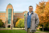 Thomas Benson stands outside the Beckman Institute on campus.