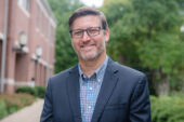 Photo of social work professor Doug Smith standing outside the School of Social Work
