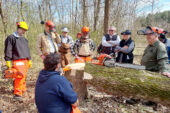 Landowners gather in a circle at a field site.
