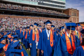 Graduates enter Memorial Stadium in May 2022 commencement
