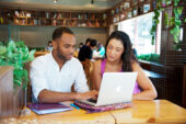 Male and female social work students studying together using a laptop computer