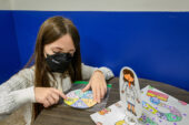 Jessica Brinkworth’s daughter, Jordan Brinkworth-Sykes, age 10, plays the game “Stop the Pathogens!” created by U. of I. student Claire von Ebers in the evolutionary immunology class.