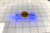 A photograph of an eBiobot prototype, lit with blue microLEDs.