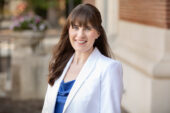 Photo of communication professor Emily Van Duyn standing in front of a campus building