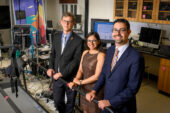Researchers stand alongside an elongated treadmill used in the research.
