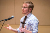 Photo of Toby Beauchamp speaking at a podium.