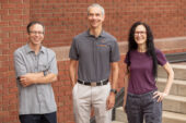 Photo of Stephen Taylor, Martin Gruebele and Carla Scaletti in front of a brick wall.