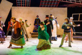 Photo of a group of actors onstage in Victorian costumes.