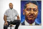 Photo of Patrick Hammie sitting on a stool next to the large portrait he painted of Albert Lee.