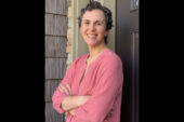 Sociology professor Ilana Redstone with her arms folded, leaning against a wall outdoors