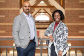 The researchers stand indoors in a brick atrium.