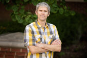 Professor Erik Procko stands with arms crossed.