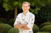 Ph.D. student Nicholas Antonson stands outdoors with his arms crossed. He is smiling.