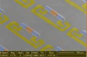 Electron microscope image of an array of new chip components that integrate the inductors, blue, and capacitors, yellow, needed to make the electronic signal filters in phones and other wireless devices.