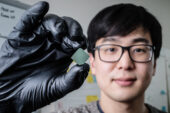 Illinois mechanical science and engineering student and lead author of a new study Benjamin Sohn holds a device that uses sound waves to produce optical diodes tiny enough to fit onto a computer chip.
