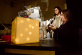 Chemistry professor Catherine Murphy, seated at the microscope, explains the work of her research team to Peggy Flavin, an environmental design student.