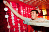 Josh Brickman, a junior in civil engineering and a board member of the Krannert Center Student Association, helps decorate the Krannert Center lobby on Nov. 29.