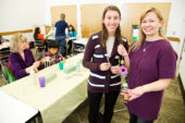 Pamela Hochwert, a senior in special education, standing left, and Michelle Bonati, a doctoral student in special education, at a Bens Bells event at Champaign Public Library.