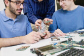 Industrial design professor Cliff Shin, center, assists graduate student Ehsan Noursalehi, left, of Naperville, Ill., and engineering student Kevin Verre, of Niles, Ill., during a meeting of the "A New Life for Laptops" research group.