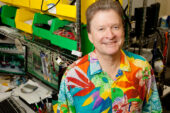 Desktop-support specialist Tim Cunningham shows off one of his signature Hawaiian shirts, which he wears to work on Fridays. Cunningham, who started his career as a factory equipment operator, once received computer training following a layoff, which led to his second career in the computer field.  Click photo to enlarge