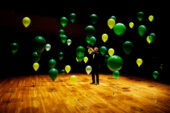 An illustration of Anderson localization. The green balloons represent disordered barriers that localize the sound of the trumpet at its source.