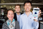Pakpoom Buabthong, a senior in physics, displays the Deployer cellphone app, which enables users to access and share animated educational videos created by Scientific Animations without Borders. Pictured with Buabthong are SAWBO co-founders Julia Bello-Bravo and Barry Pittendrigh.