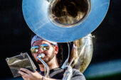 The worn turf of the Marching Illini's temporary practice field is reflected in the bell of sousaphone player Richie Faling's horn.