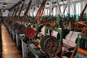 Photo of a row of looms in a textile mill.