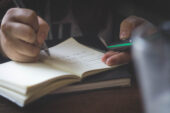 Hands of a student writing in a book