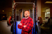 Portrait of Nicholas Burd standing in front of a weight rack.