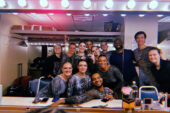 Photo of a group of dancers in costume reflected in a dressing room mirror.