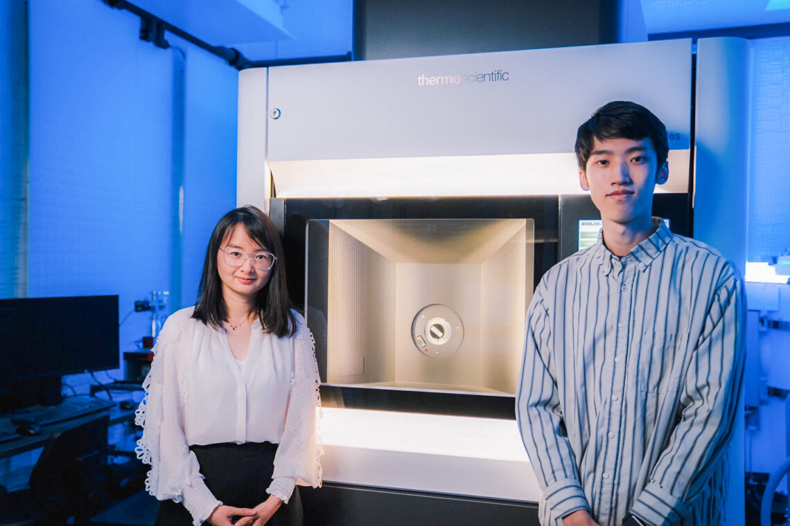 This image researchers standing in front of an electron microscope at the University of Illinois Urbana-Champaign