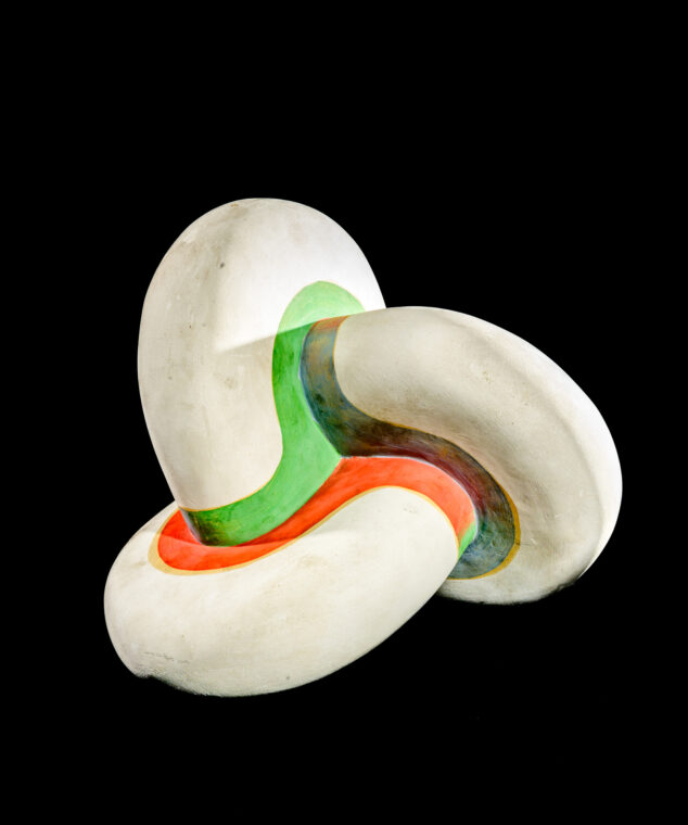 Photo of a curving plaster model with three spheres intersecting, with green and orange painted areas.