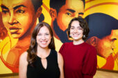 Social work professor Tara Powell and graduate student Jenna Muller standing in front of a mural of Black young people.