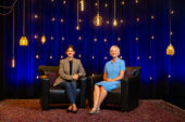 Sakshi Bhalla and Michelle Nelson sitting before a blue background