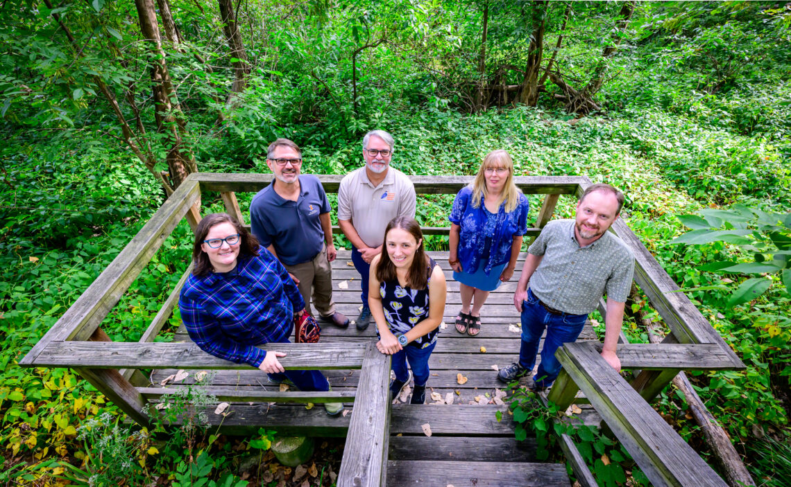 Research team stands on a observation deck in Busey Woods.