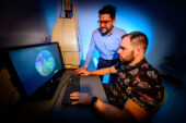 Photo of the two researchers looking at a computer monitor displaying a cross-section of muscle fibers, with different colors representing different muscle fiber types.