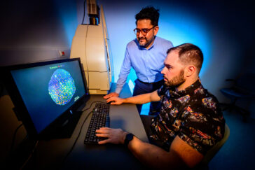 Photo of the two researchers looking at a computer monitor displaying a cross-section of muscle fibers, with different colors representing different muscle fiber types.