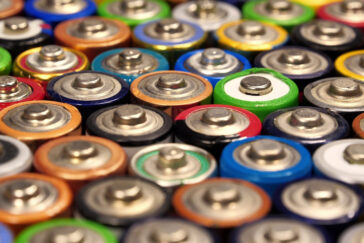 A tilted view of miscellaneous of multicolored used batteries.
