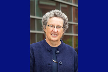 A woman with glasses wearing dark blue