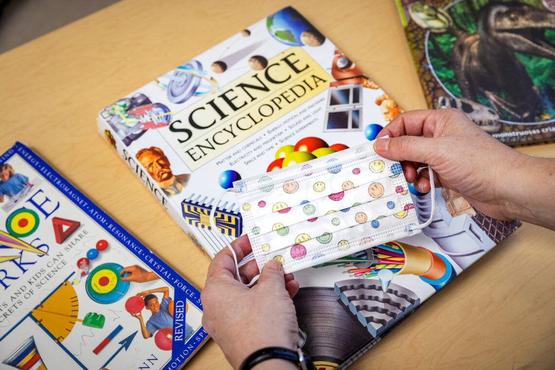 Close-up of child's mask and elementary books.The task of keeping children safe and in school was a formidable challenge for educators, parents and community leaders. Photo by Michelle Hassel