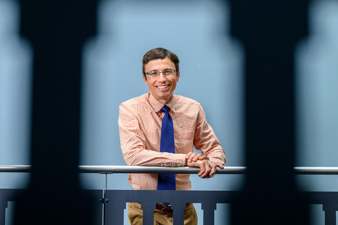 A man leaning on one elbow on a metal stair railing.