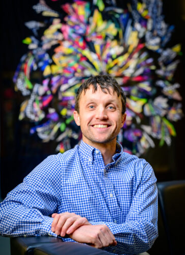 A man leaning on one elbow and smiling