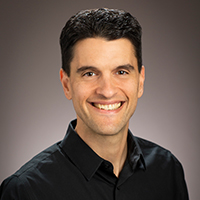 Studio portrait of a man smiling.