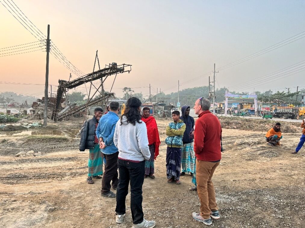 A photo of the researchers hearing the stories of local laborers at a stone processing site.