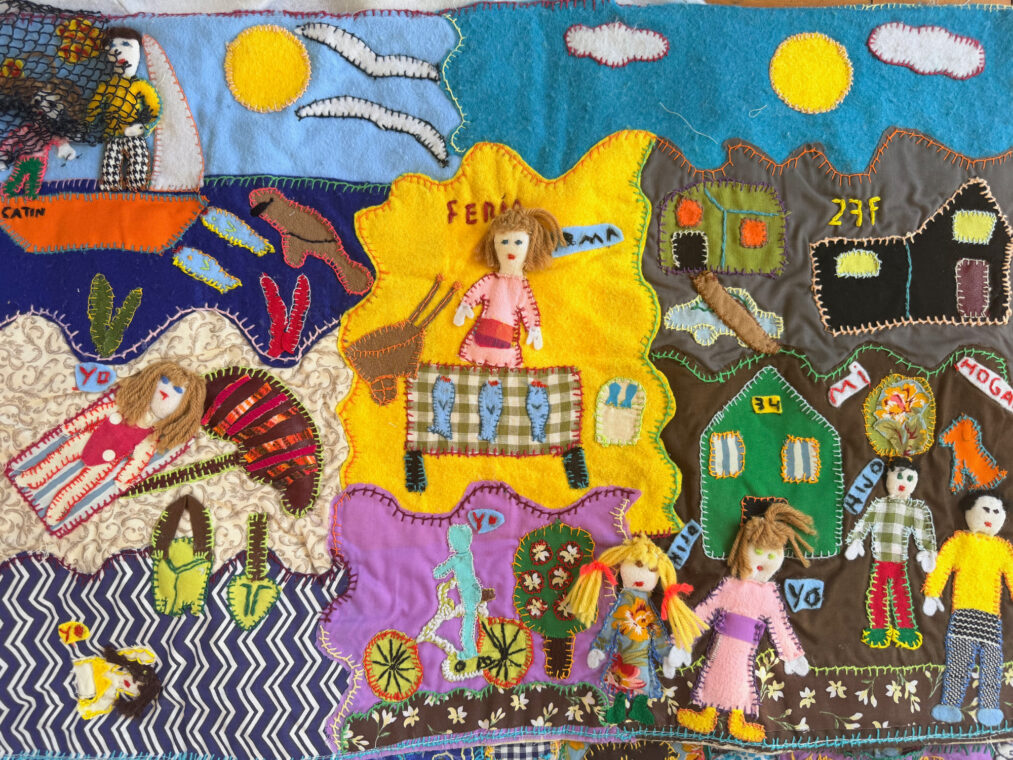 Photo of an arpillera showing scenes from the seaside and fishing.